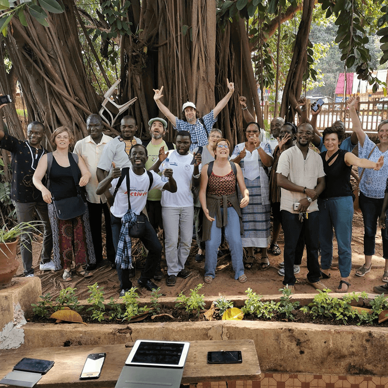 Un groupe de gens travaillent et discutent à genoux dans une forêt
